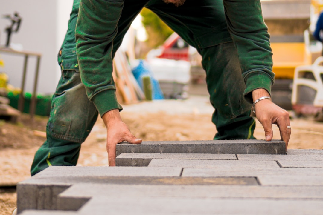 Worker arranging bricks for a paver patio project